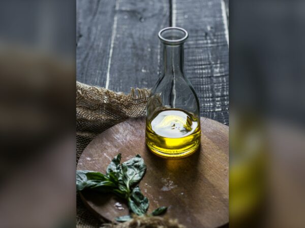 Γυάλινο μπουκάλι με ελαιόλαδο σε ξύλινο τραπέζι